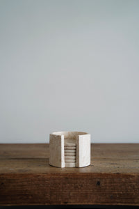 Polished marble coasters and holder in sand