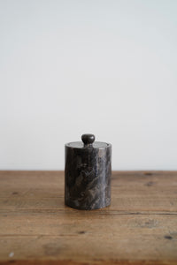 A grey polished marble jar with removable lid
