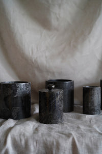 A grey polished marble jar with removable lid