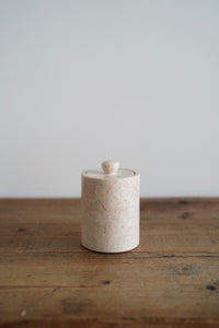 A natural polished marble jar with removable lid