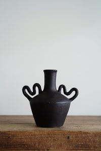 This handmade rustic vase with unique curved handles and a dark chocolate brown finish