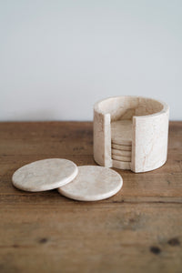 Polished marble coasters and holder in sand