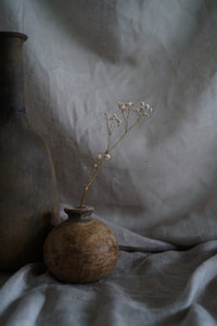 A hand thrown clay vessel with an organic textured finish. Perfect for dried blooms