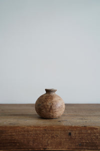 A hand thrown clay vessel with an organic textured finish